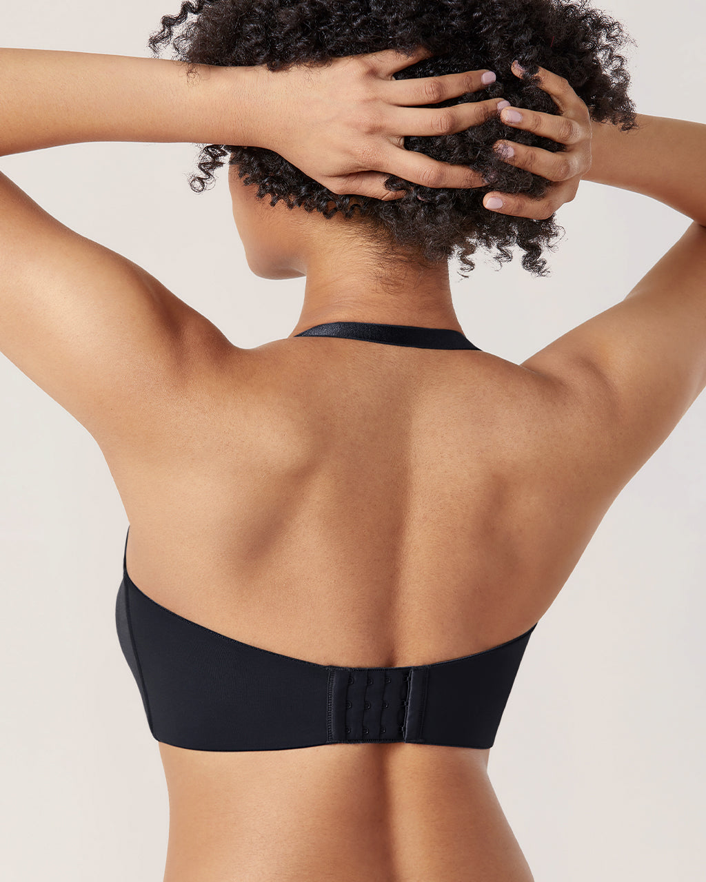 Angle view of black seamless strapless bra showing plunge neckline and molded unpadded cups - MissFine