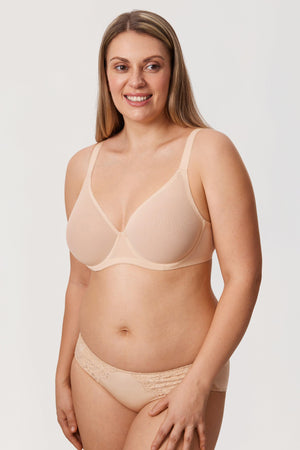 Woman wearing a beige bra and panties set on a white background