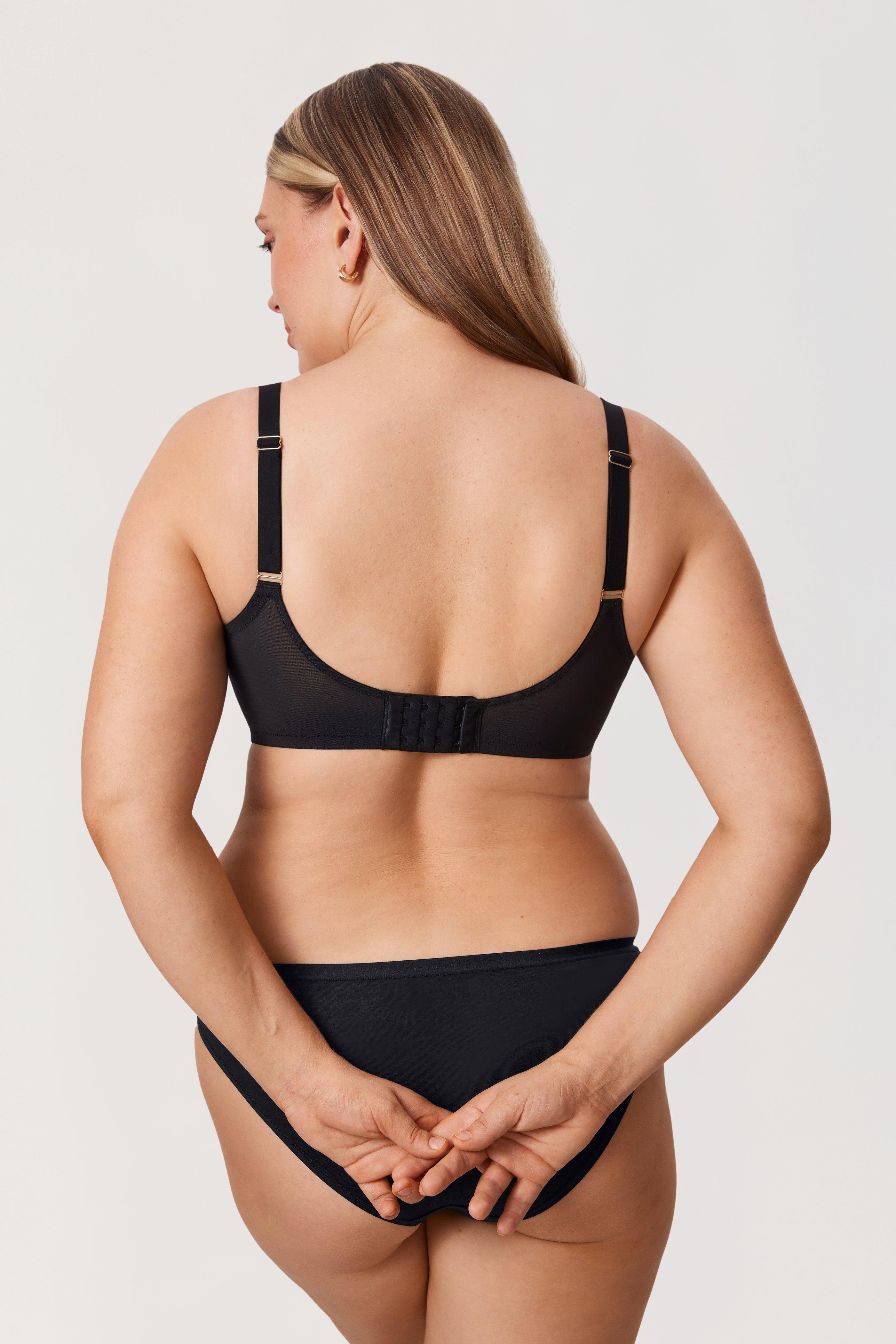 Woman wearing a black bikini set on a plain background