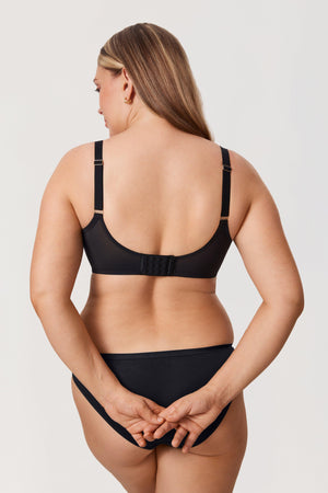 Woman wearing a black bikini set on a plain background